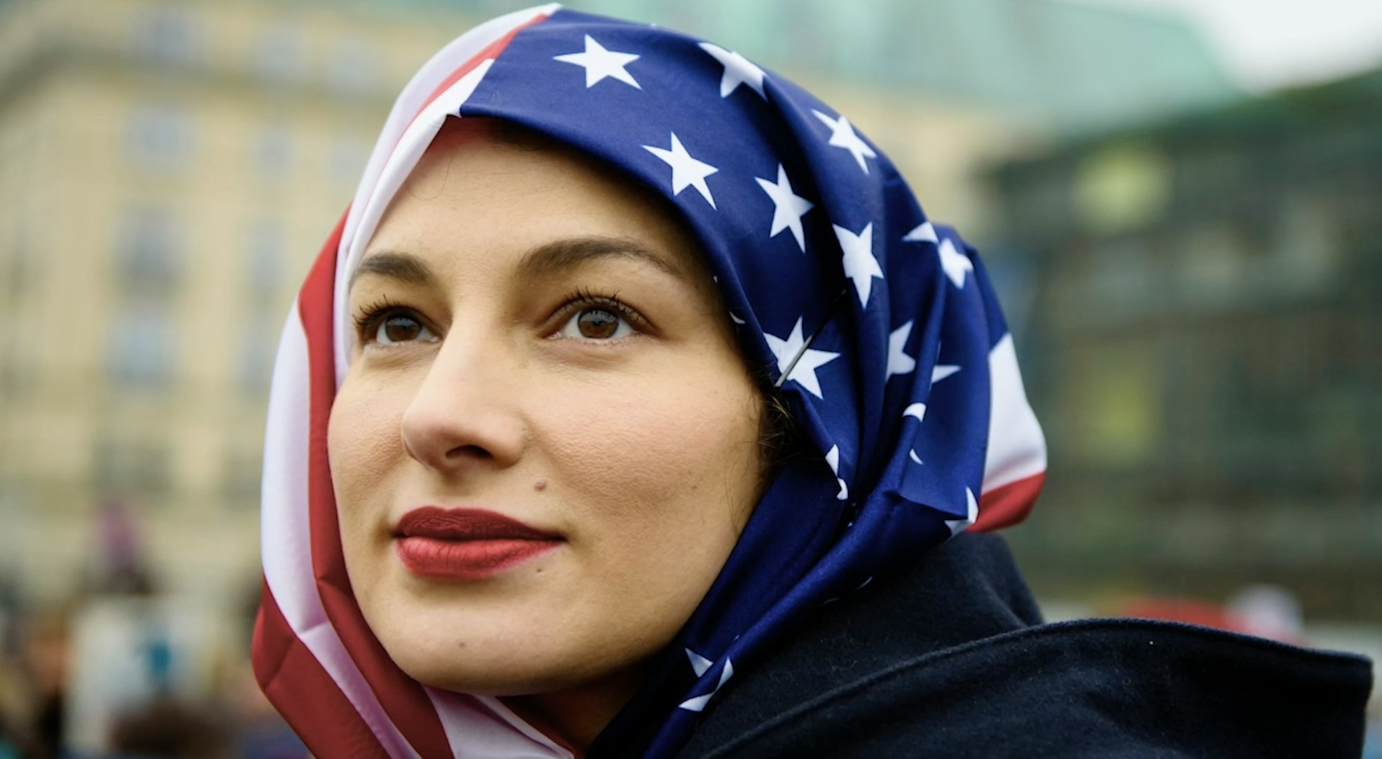 A still from the film We Rise featuring a young woman wearing an american flag hijab
