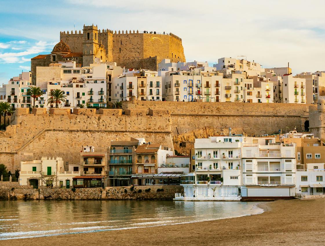 an image of an old city along the Iberian coast with beige buildings rising from the sea and a blue sky, used on the brochure for Floating University