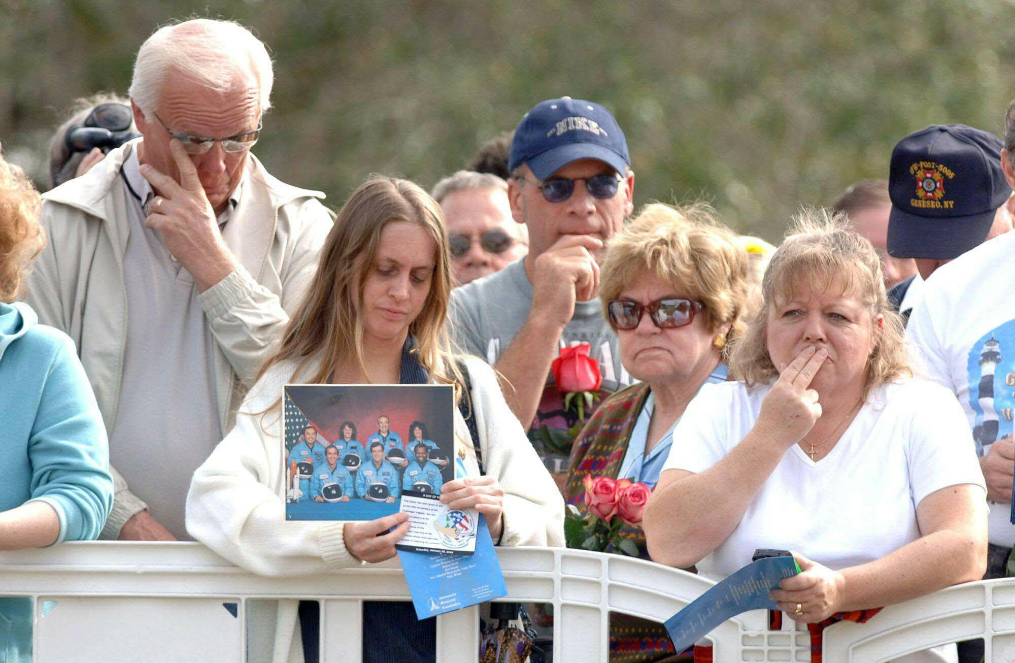 Red Huber, Tanya Southward, center, holds a shuttle Challenger crew photograph at a public memorial service at Kennedy Space Center Visitors Complex, marking the 20th anniversary of the shuttle Challenger disaster. January 28, 2006. Orlando Sentinel / Tribune News Service via Getty Images.