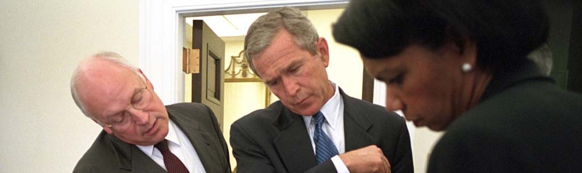 President George W. Bush looks over a briefing paper with Vice President Dick Cheney and National Security Advisor Dr. Condoleezza Rice, September 12, 2001, outside the Oval Office