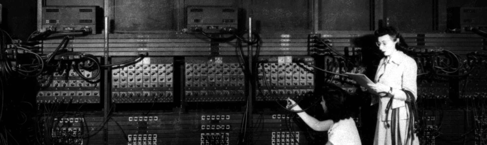 Two women wiring the right side of the ENIAC with a new program. Standing: Marlyn Wescoff Crouching: Ruth Lichterman, cc. 1946.