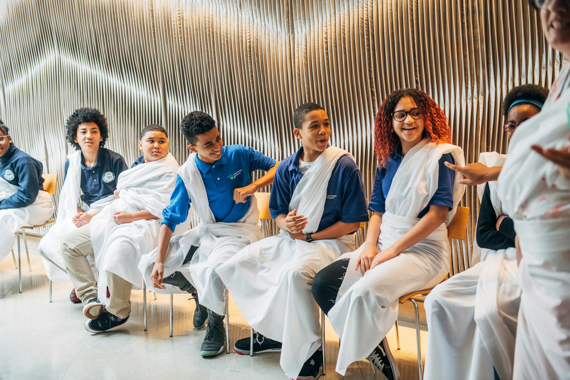 Students dressed in togas and sitting in a classroom.