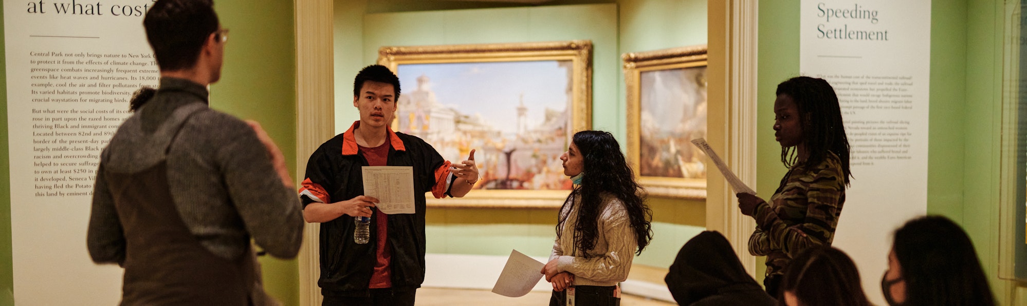 students tour a gallery together and get a presentation from an educator