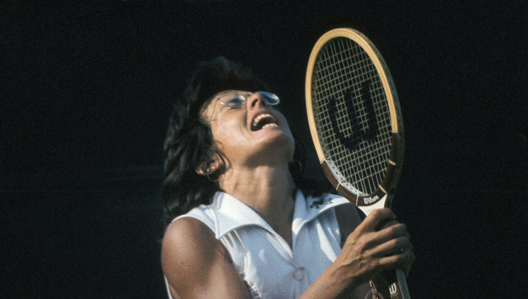 Billie Jean King clutches her racquet and looks to the sky in 1973