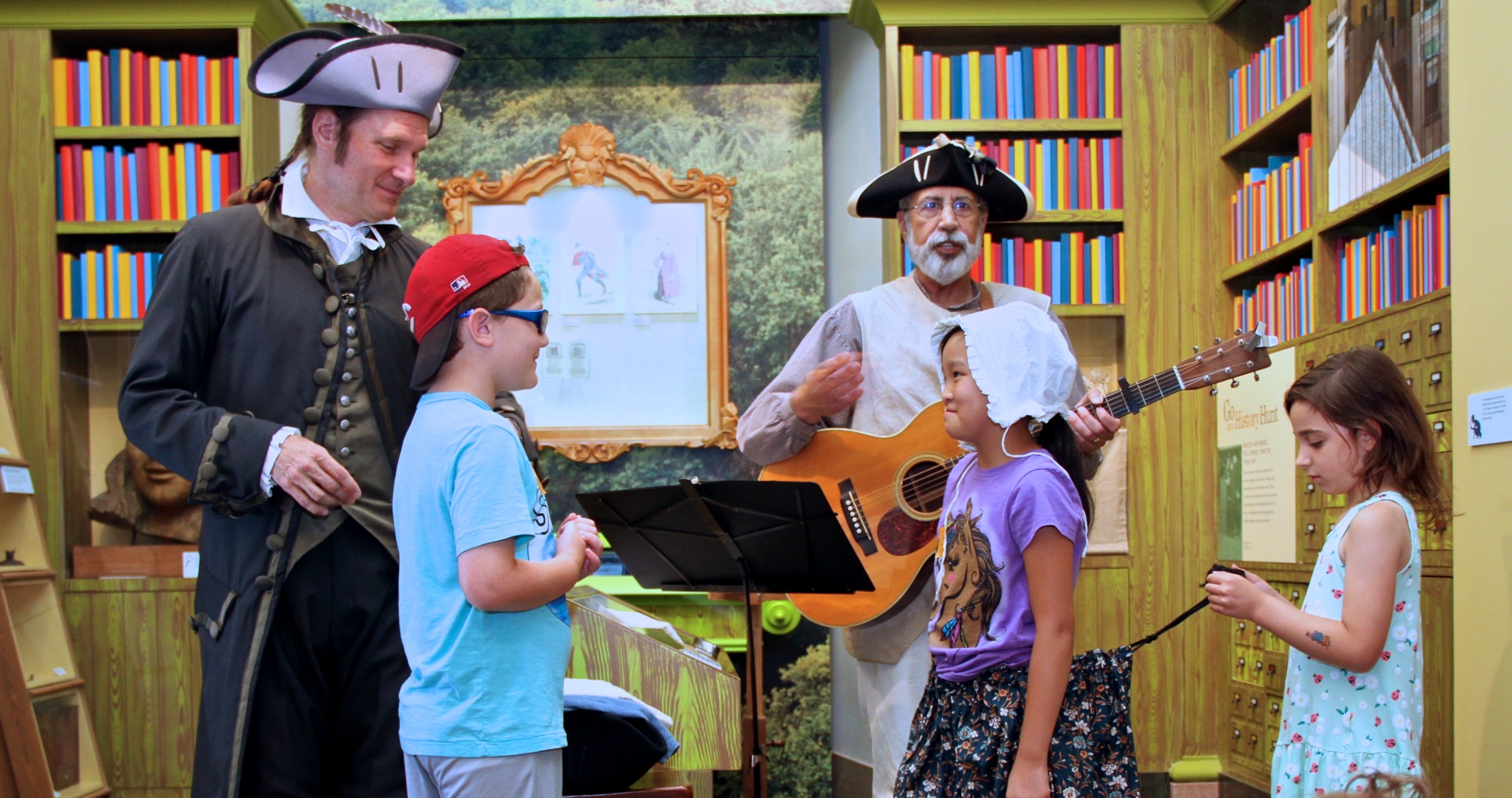 living historians interact with a group of children in the children's museum library