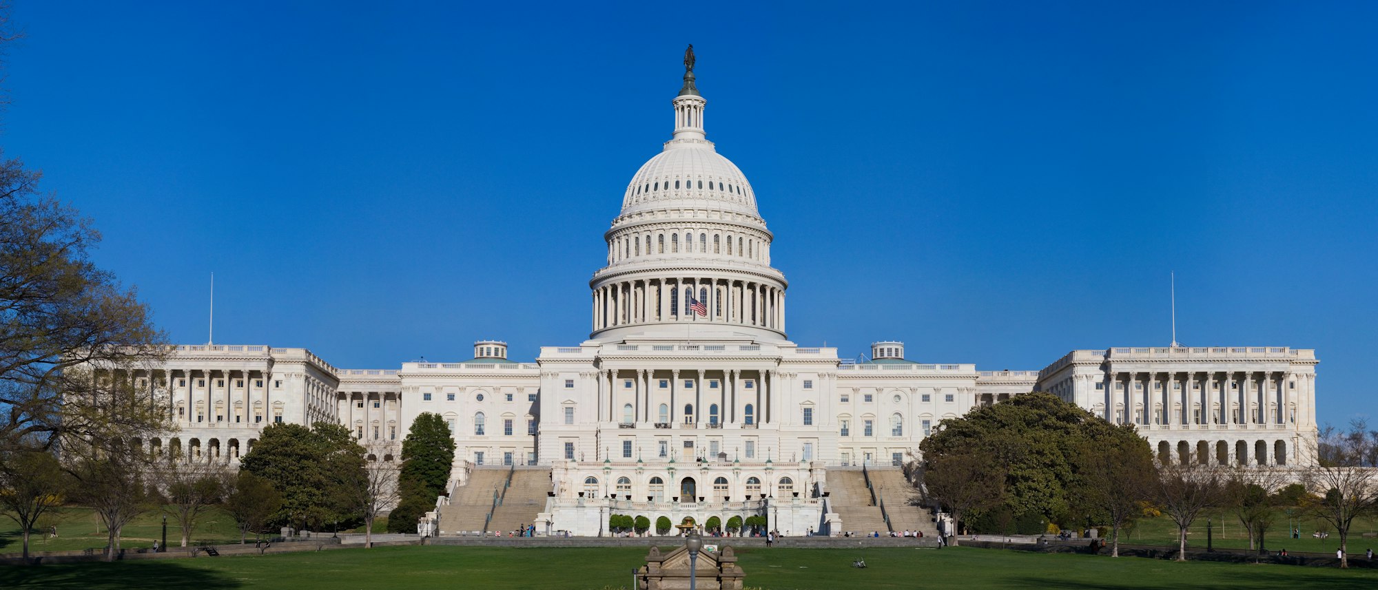 a front view of the capital building in Washington D.C. on a sunny day with a blue sky in the background
