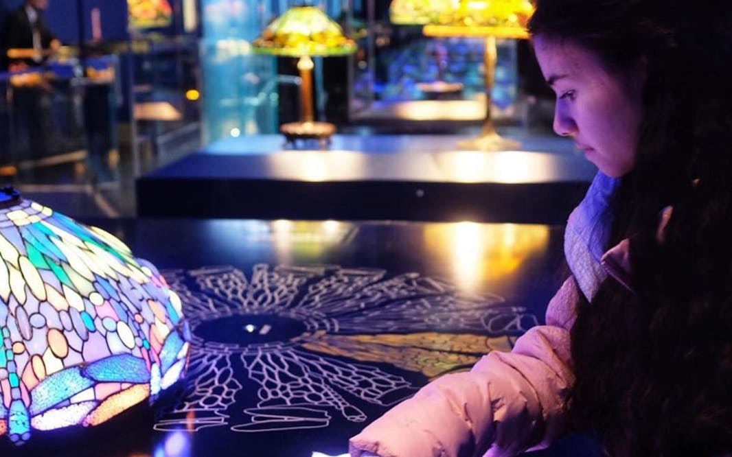 person pointing to an exhibition of a tiffany lamp