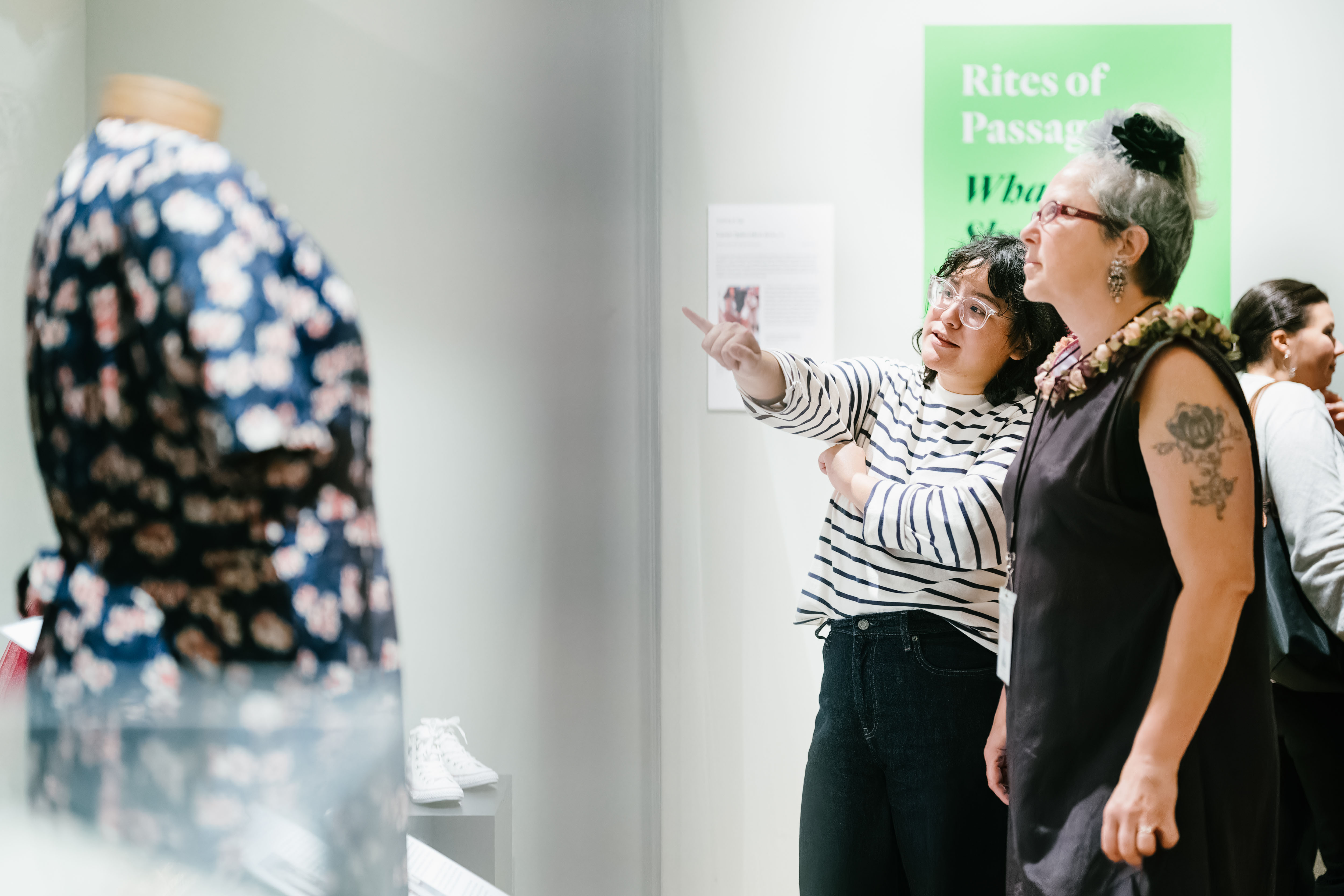 two women visitors look at a garment in the exhibition Real Clothes, Real Lives