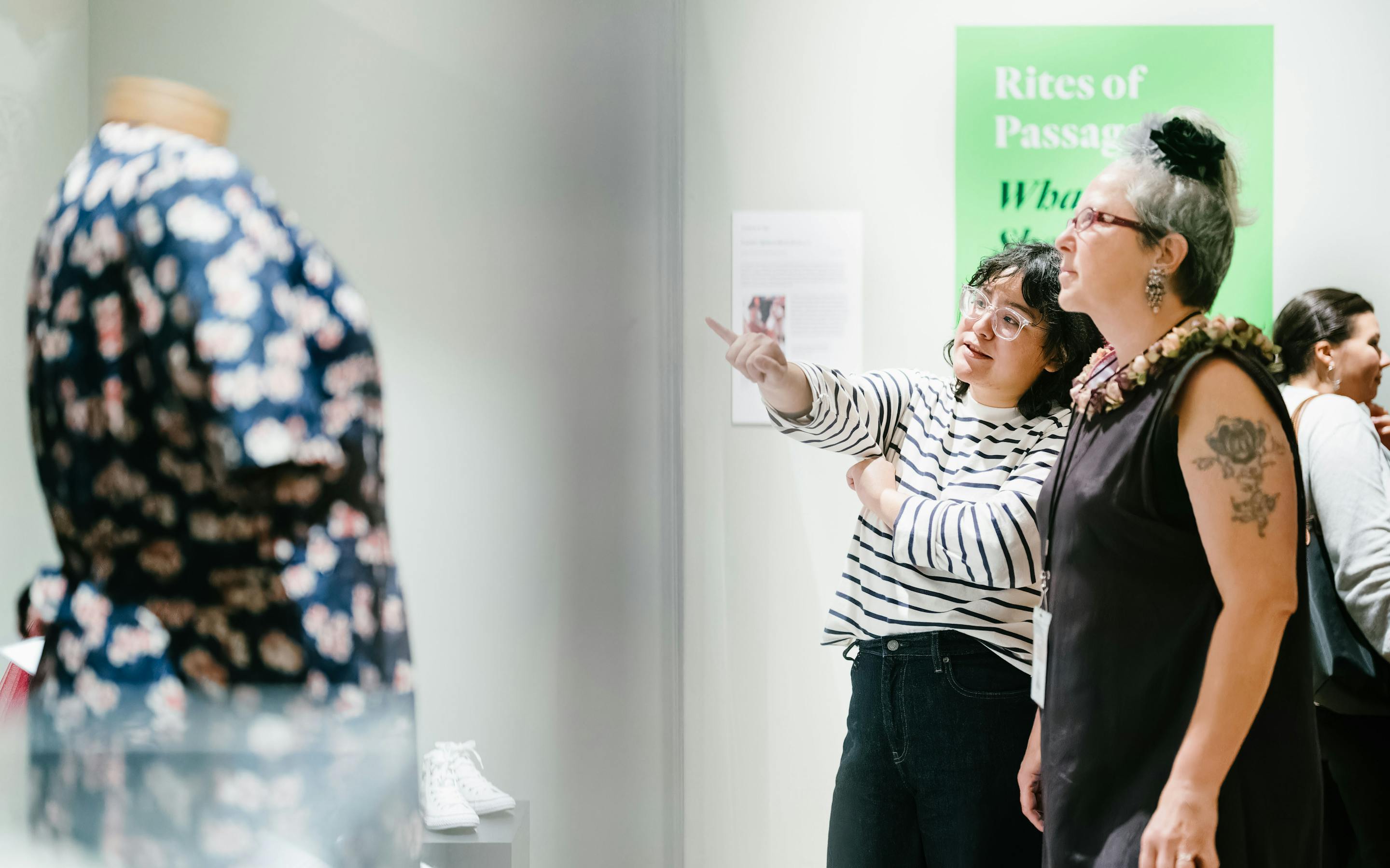 two women visitors look at a garment in the exhibition Real Clothes, Real Lives
