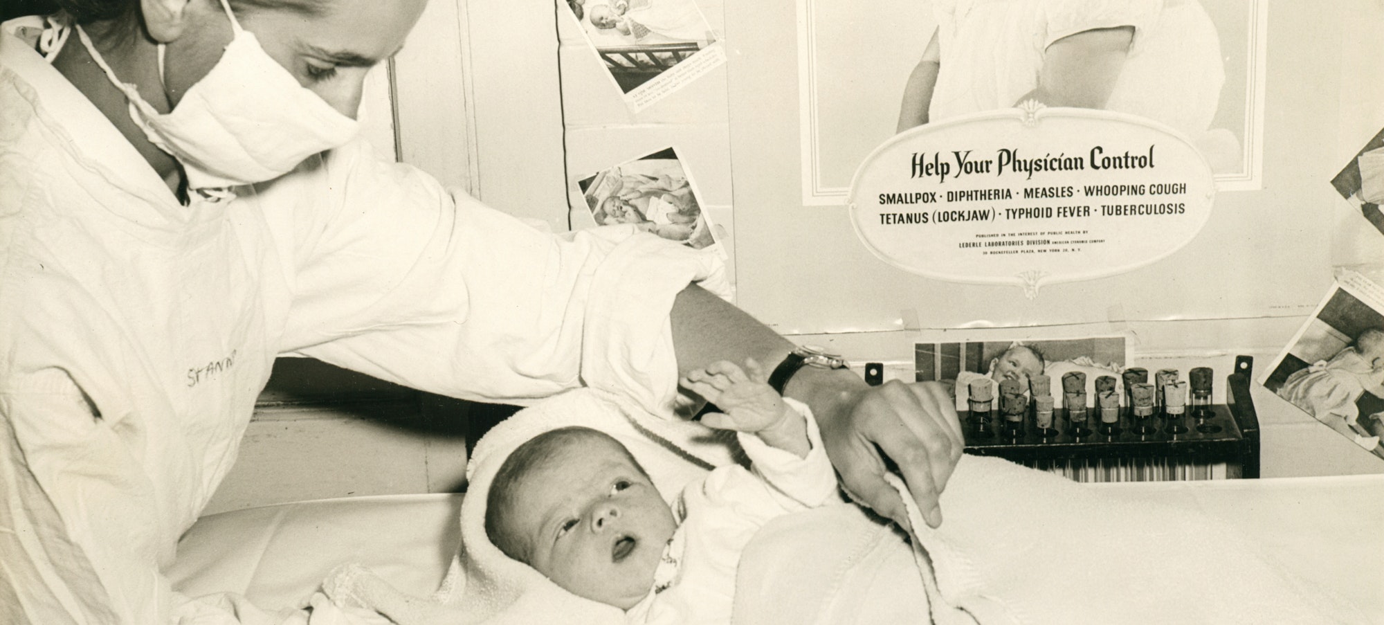 Black and white image of nurse and infant in front of "Help your physician control smallpox, diphtheria, measles, whooping cough, tetanus (lockjaw), typhoid fever, tuberculosis" poster, date unknown