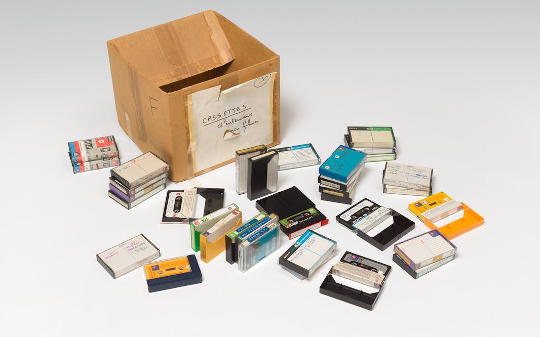 a cardboard box with a number of cassette tapes spilled out in front of it.