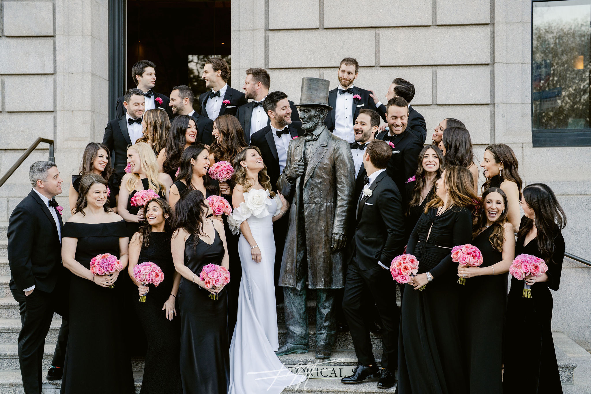 casual, group wedding photo of a wedding party outside on the N-YHS steps around the Lincoln statue