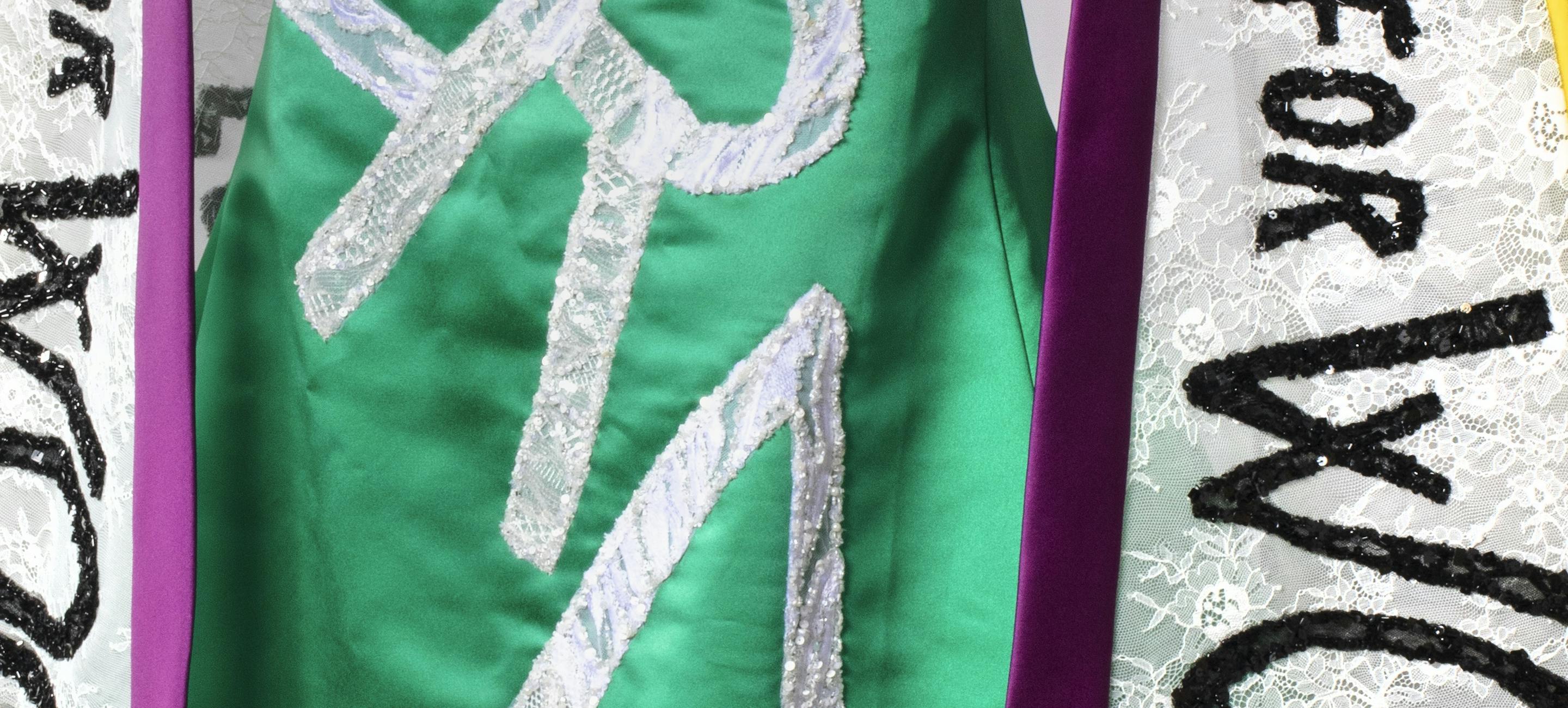 detail of the gown worn by Carolyn Maloney to the Met Gala showing ERA on the body and votes for women on the sash