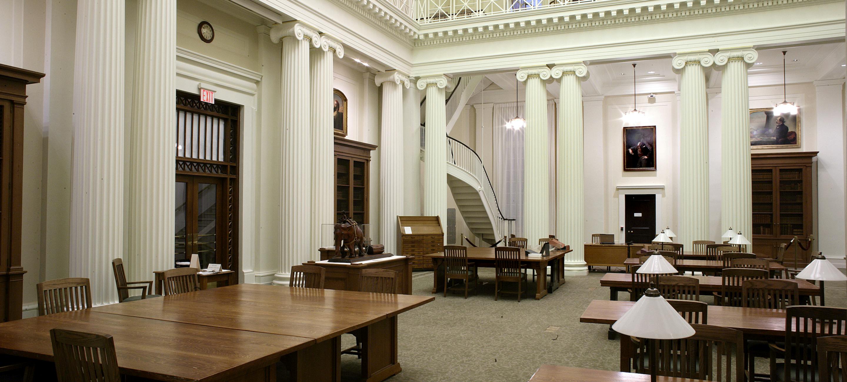 a shot of the empty reading room of the library with tables and chairs set up.