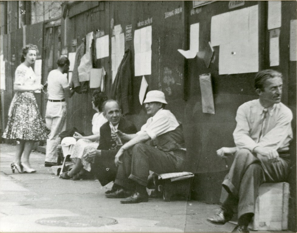 Cuervos vendiendo poesía en Washington Square South y Thompson Street, década de 1930. Mcrudden es el segundo desde la derecha. Bodenhiem está en el extremo derecho. Colección del Círculo de Poesía Raven de Greenwich Village, PR108.